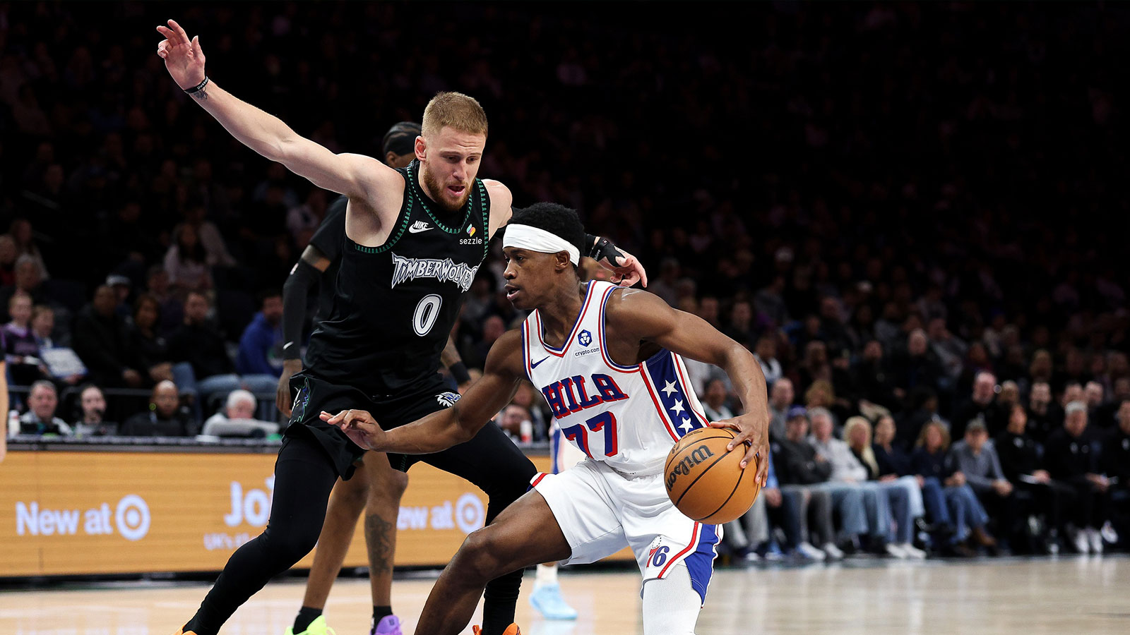 Philadelphia 76ers guard Vj Edgecombe (77) drives towards the basket as Minnesota Timberwolves guard Donte DiVincenzo (0) defends during the first half at Target Center.