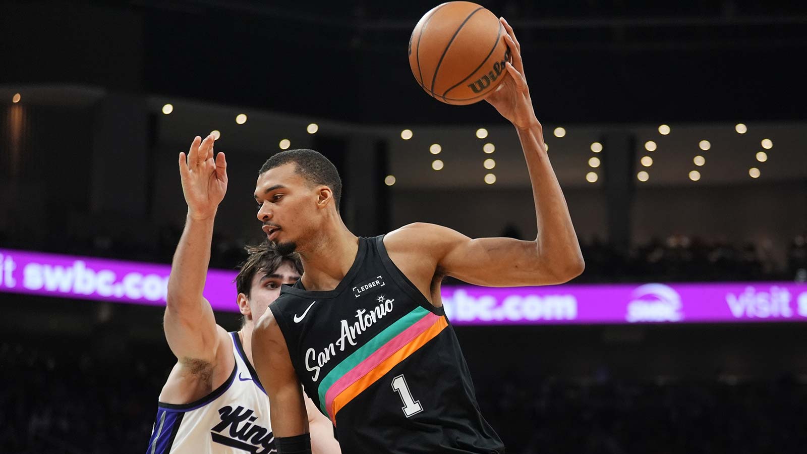 San Antonio Spurs forward Victor Wembanyama (1) controls the ball in front of Sacramento Kings center Maxime Raynaud (42) in the first half at Moody Center.