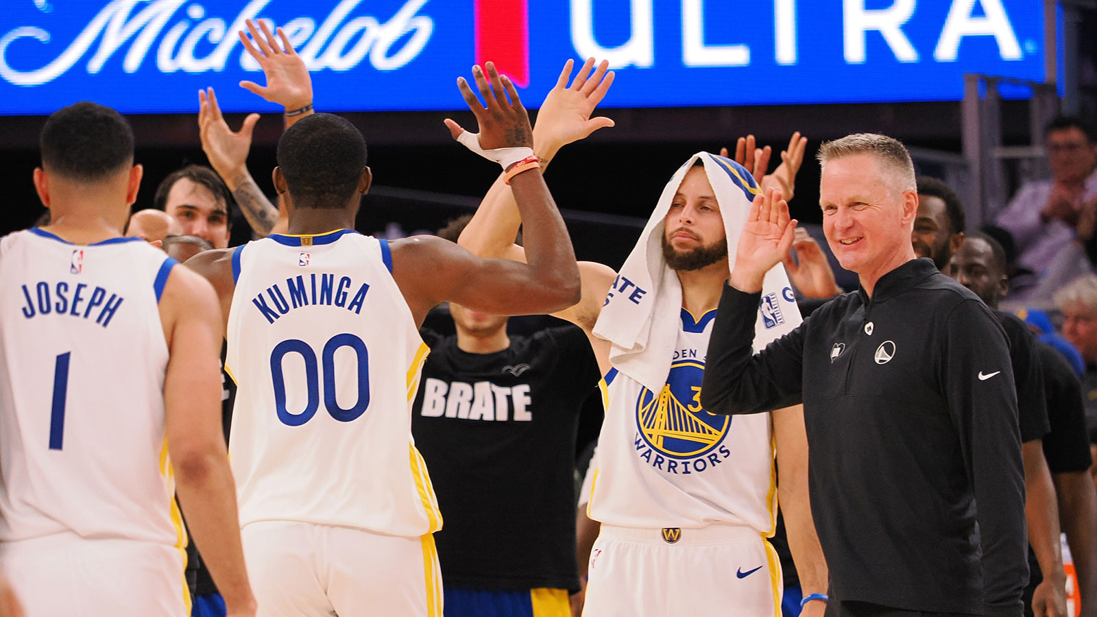 Warriors forward Jonathan Kuminga (00) high fives guard Stephen Curry (30) and head coach Steve Kerr as a time out is called against the Atlanta Hawks during the fourth quarter at Chase Center