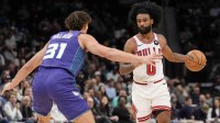 Chicago Bulls guard Coby White (0) brings the ball up court against Charlotte Hornets forward Tidjane Salaun (31) during the second half at Spectrum Center.