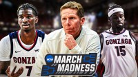 Gonzaga HC Mark Few (front, center) with Gonzaga C Graham Ike and Gonzaga SG Tyon Grant-Foster. March Madness logo in background