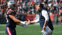 New England Patriots head coach Mike Vrable congratulates offensive tackle Will Campbell (66) after a touchdown during the first half against the Carolina Panthers at Gillette Stadium.