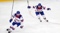 Zach Werenski (8) and Jack Hughes (86) of the United States celebrate after winning the men's ice hockey gold medal game during the Milano Cortina 2026 Olympic Winter Games at Milano Santagiulia Ice Hockey Arena.