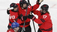 Kristin O'Neill of Canada celebrates scoring their first goal with Marie-Philip Poulin of Canada and Ella Shelton of Canada against Czechia in women's ice hockey group B play during the Milano Cortina 2026 Olympic Winter Games at Milano Rho Ice Hockey Arena.