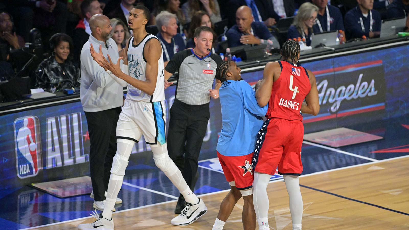 Feb 15, 2026; Inglewood, California, USA; Team World center Victor Wembanyama (1) of the San Antonio Spurs reacts as Team USA Stars forward Scottie Barnes (4) of the Toronto Raptors celebrates with Tyrese Maxey (0) of the Philadelphia 76ers after game one during the 75th NBA All Star Game at Intuit Dome. Mandatory Credit: Jayne Kamin-Oncea-Imagn Images