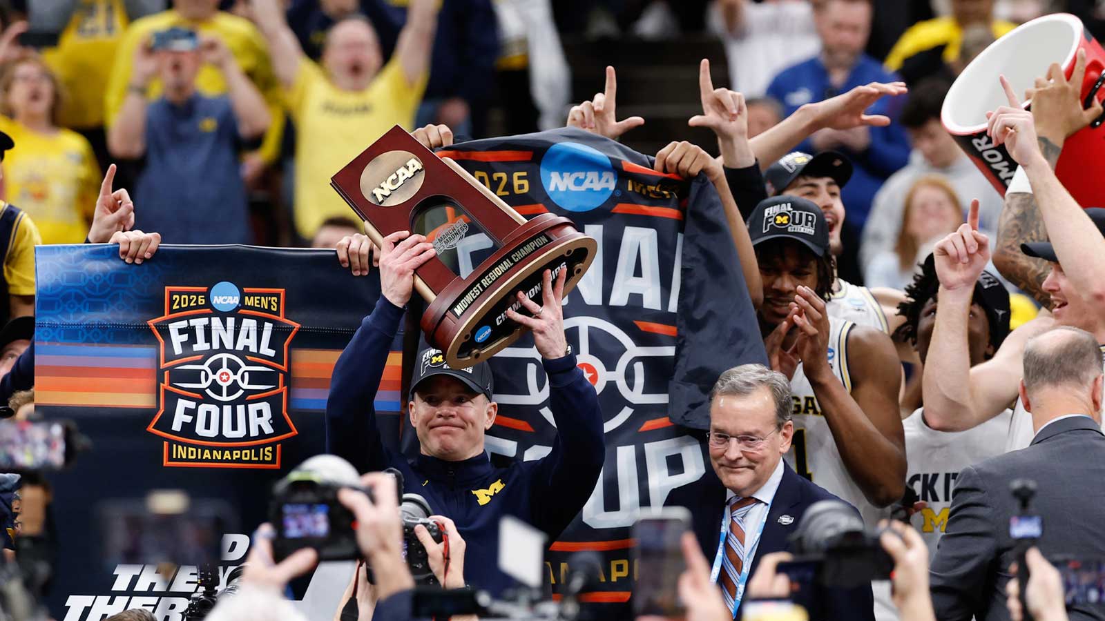 Michigan Wolverines head coach Dusty May lifts the Midwest Regional Champion trophy after defeating the Tennessee Volunteers in an Elite Eight game of the men's 2026 NCAA Tournament at United Center.