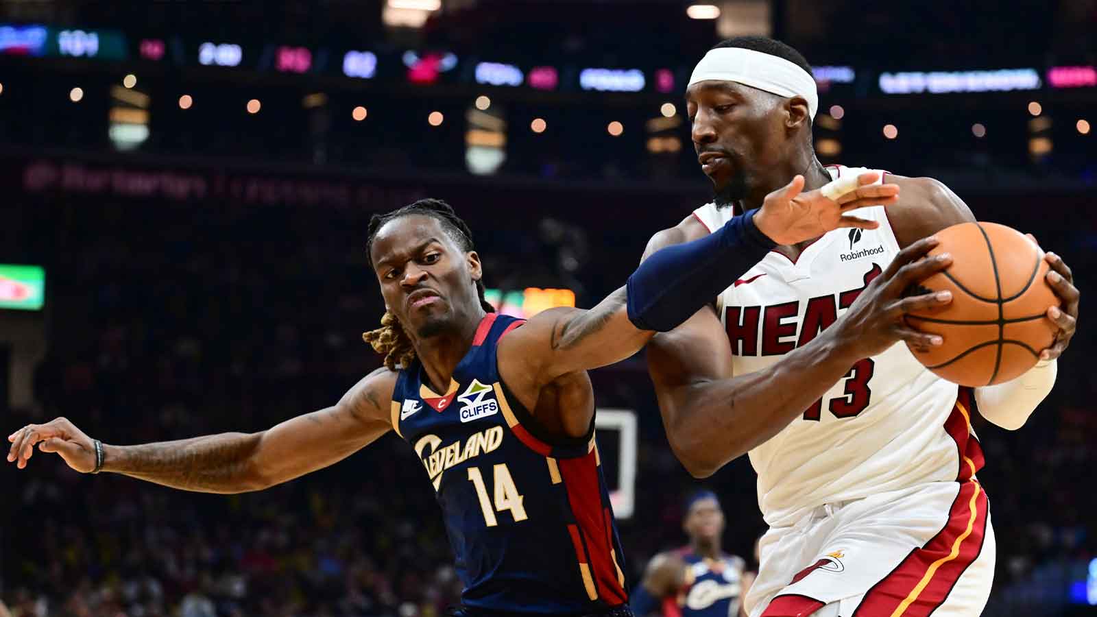 Cleveland Cavaliers guard Keon Ellis (14) goes for a loose ball against Miami Heat center Bam Adebayo (13) during the second half at Rocket Arena.
