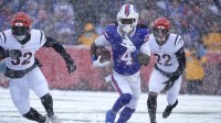 Buffalo Bills running back James Cook III carries the ball getting past Cincinnati Bengals running back Gary Brightwell and safety Geno Stone during first half action at Highmark Stadium.