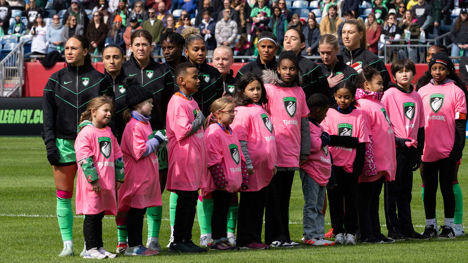 https://wp.clutchpoints.com/wp-content/uploads/2026/03/Boston-Legacy-FC-starters-line-up-for-the-national-anthem-before-teams-debut-game-against-Gotham-FC-.jpg