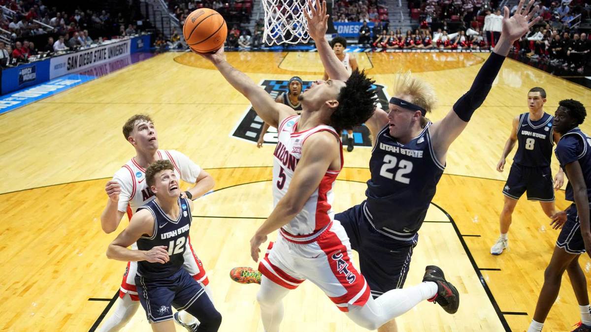 Arizona Wildcats guard Brayden Burries (5) shoots against Utah State Aggies guard Mason Falslev (12) and forward Karson Templin (22) in the first half during a second round game of the men's 2026 NCAA Tournament at Viejas Arena.