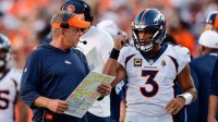 Denver Broncos head coach Sean Payton talks with quarterback Russell Wilson (3) in the fourth quarter against the Washington Commanders at Empower Field at Mile High.