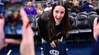 Indiana Fever guard Caitlin Clark reacts to her logo being on the back of her court chair before the game between the Indiana Pacers and the Los Angeles Lakers at Gainbridge Fieldhouse.