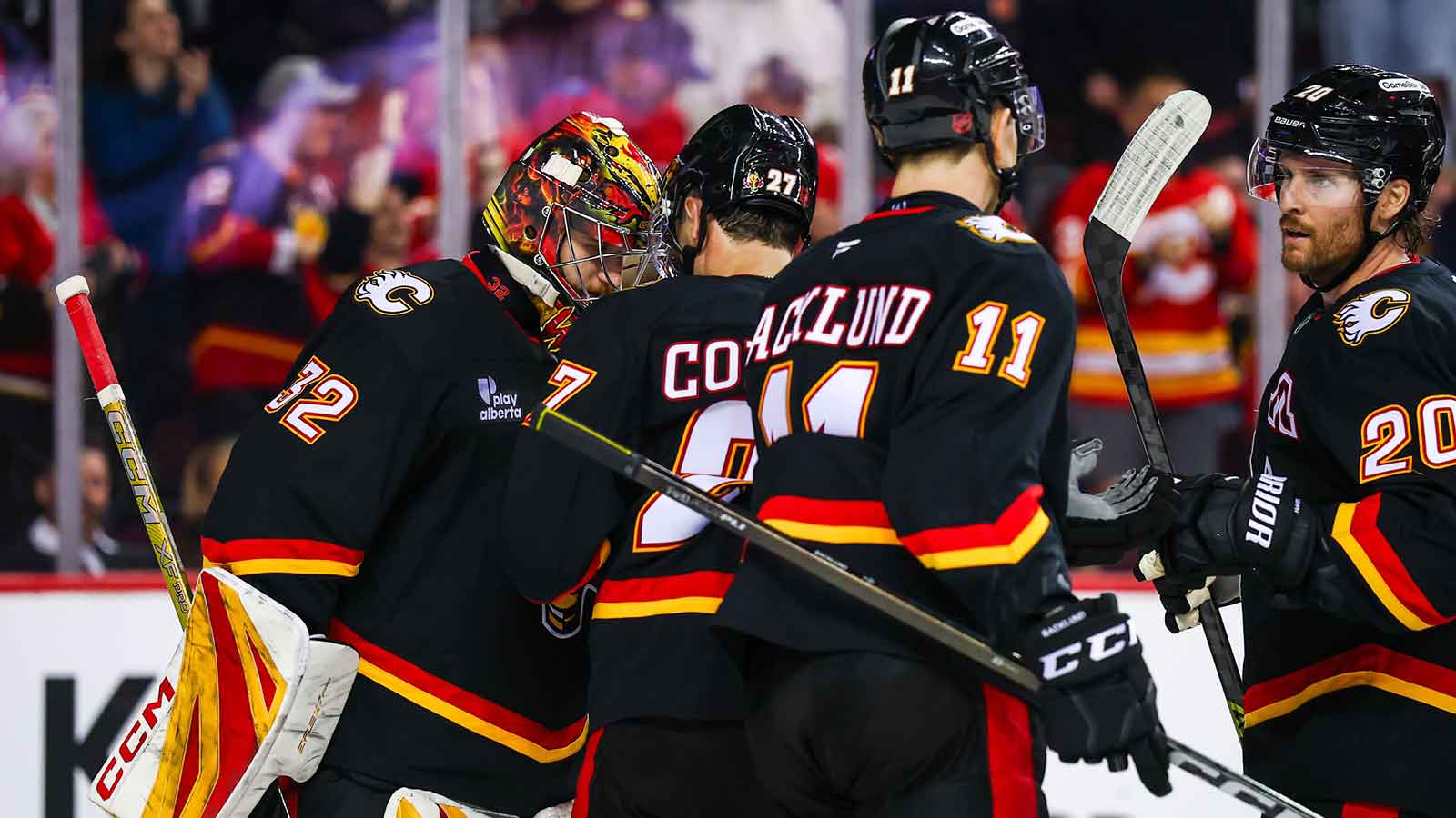 Calgary Flames goaltender Dustin Wolf (32) celebrates win with teammates after defeating Carolina Hurricanes at Scotiabank Saddledome.