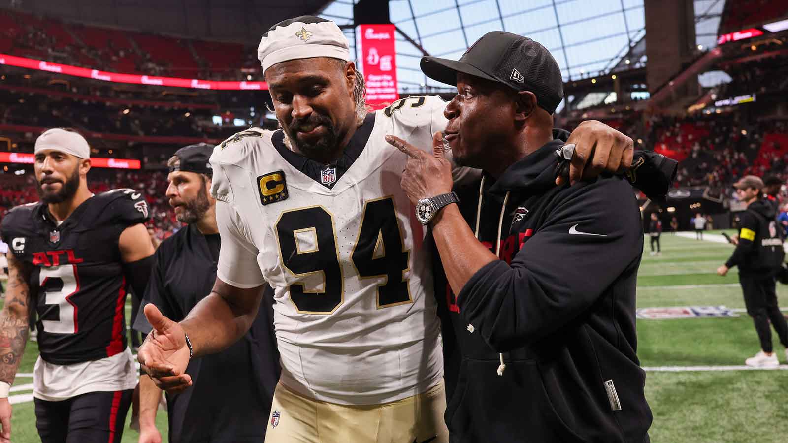 New Orleans Saints defensive end Cameron Jordan (94) walks with Atlanta Falcons head coach Raheem Morris after a game at Mercedes-Benz Stadium.