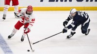 Boston University Terriers defenseman Cole Hutson (44) controls the puck as Penn State Nittany Lions forward Reese Laubach (29) defends during the first period of the Frozen Four college ice hockey national semifinals at Enterprise Center.