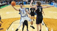 Duke Blue Devils guard Cayden Boozer (2) shoots as Texas Christian University Horned Frogs guard Liutauras Lelevicius (3) defends in the second half during a second round game of the men's 2026 NCAA Tournament at Bon Secours Wellness Arena.