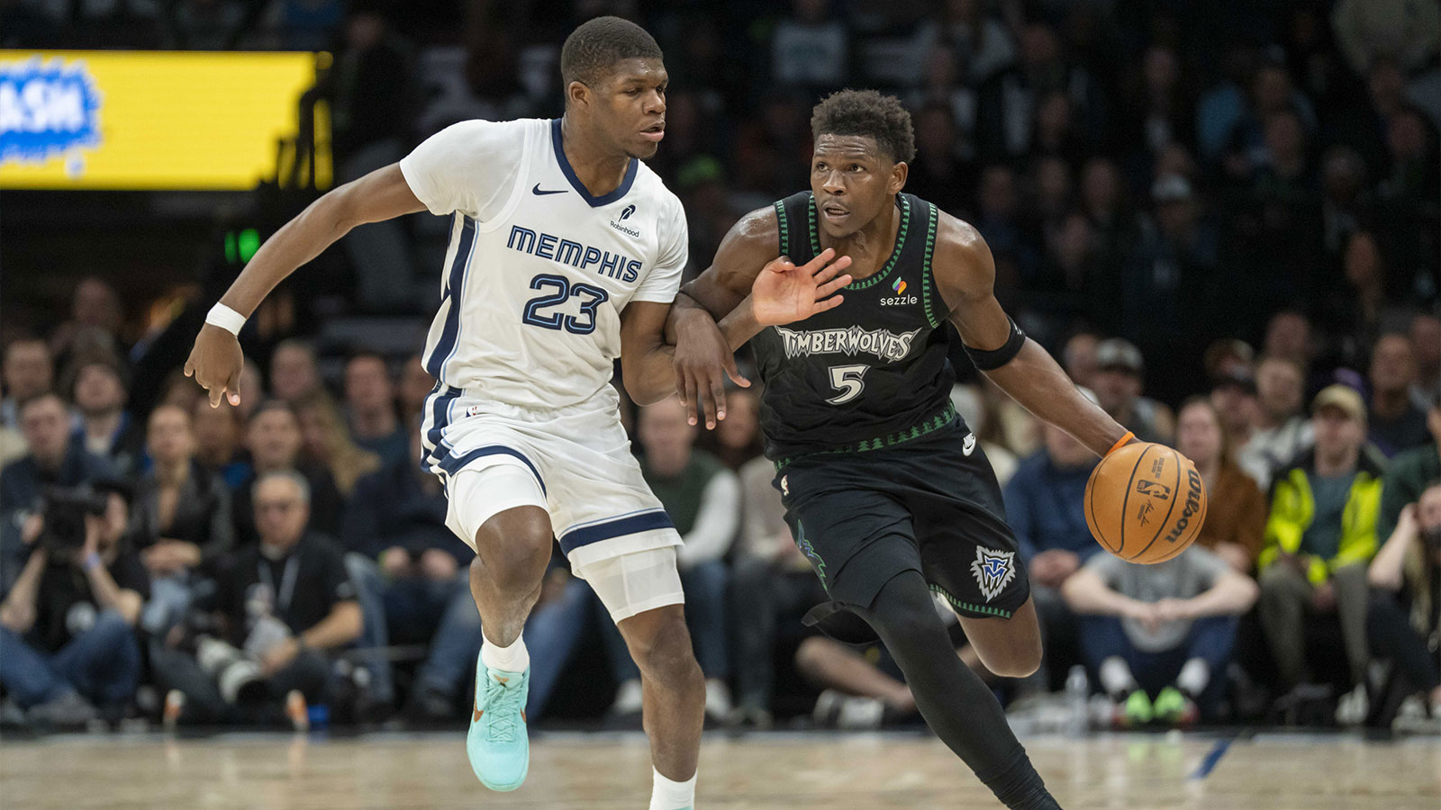 Minnesota Timberwolves guard Anthony Edwards (5) dribbles the ball past Memphis Grizzlies forward Cedric Coward (23) in the second half at Target Center.