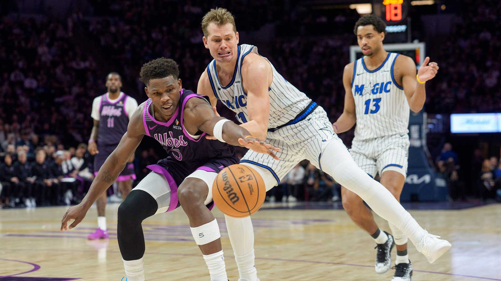 Minnesota Timberwolves guard Anthony Edwards (5) and Orlando Magic forward Moritz Wagner (21) play a loose ball in the third quarter at Target Center.