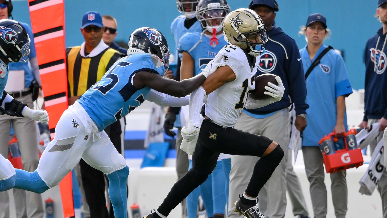 New Orleans Saints wide receiver Chris Olave (12) runs with the ball after a made catch as Tennessee Titans linebacker Jihad Ward (533) chases during the first half at Nissan Stadium