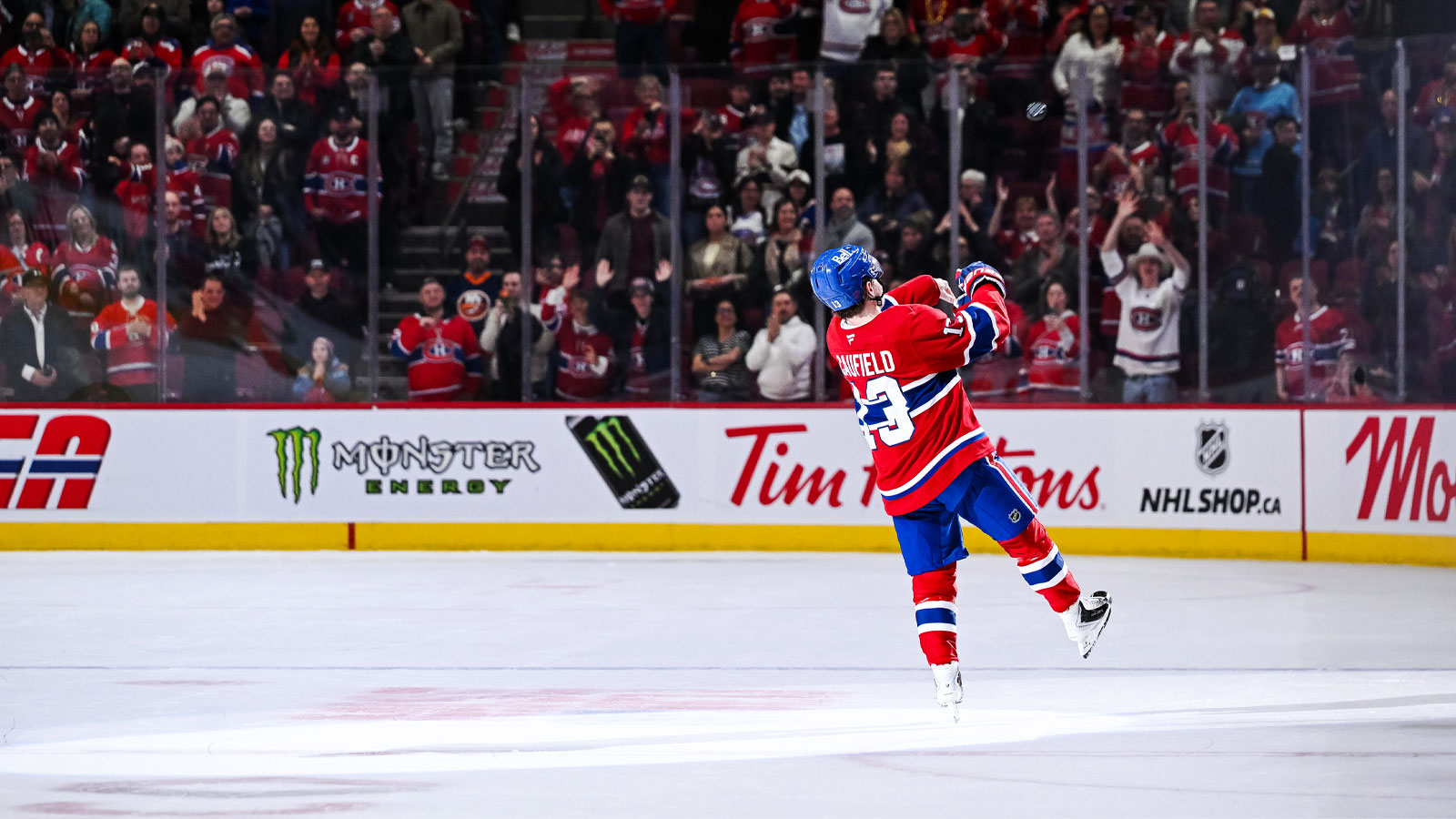 Montreal Canadiens right wing Cole Caufield (13), first star of the game, throws pucks to the fans after the game against the New York Islanders at Bell Centre.