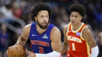 Detroit Pistons guard Cade Cunningham (2) takes the ball up the court past Atlanta Hawks forward Jalen Johnson (1) in the first quarter at Little Caesars Arena.