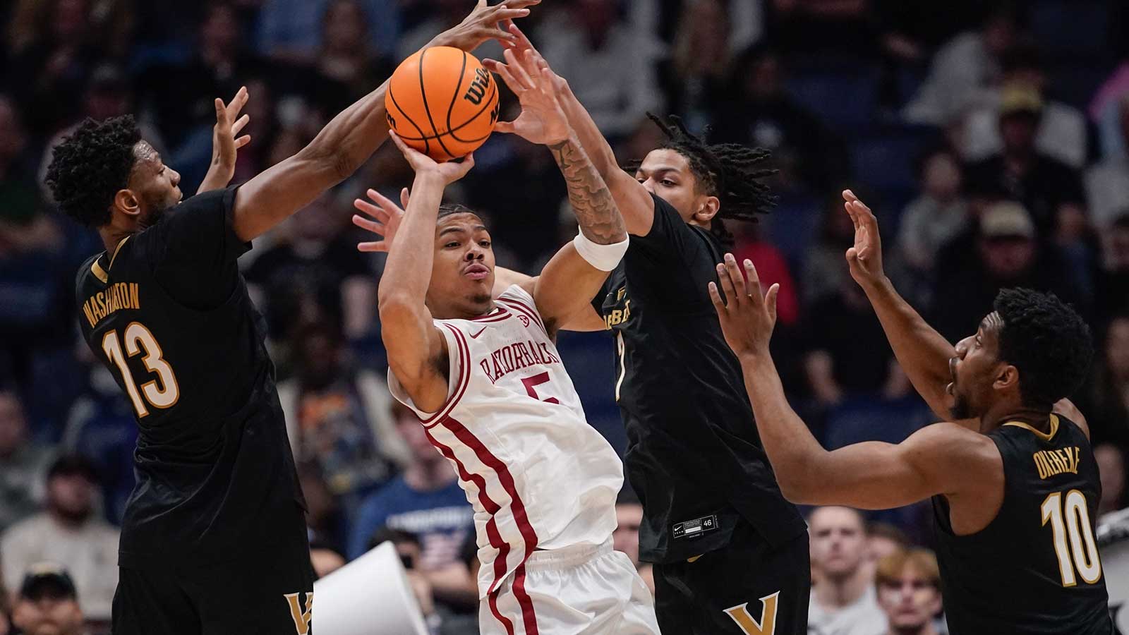 Arkansas guard Darius Acuff Jr. (5) passes between Vanderbilt forward Jalen Washington (13) and guard Chandler Bing (7) during the first half of the SEC tournament championship game at Bridgestone Arena in Nashville, Tenn., Sunday, March 15, 2026.