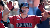 Arizona Diamondbacks left fielder Corbin Carroll (7) celebrates in the dugout after hitting a three-run home run during the eighth inning off Los Angeles Dodgers relief pitcher Tanner Scott (66) at Dodger Stadium.