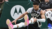 Milwaukee Bucks forward Giannis Antetokounmpo (34) holds his knee after dunking a basket against the Indiana Pacers in the third quarter and had to leave the game at Fiserv Forum.