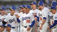 Los Angeles Dodgers manager Dave Roberts (30) poses with players during the World Series ring ceremony before the game against the Arizona Diamondbacks at Dodger Stadium.