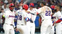 Dominican Republic catcher Austin Wells (28) is mobbed by teammates