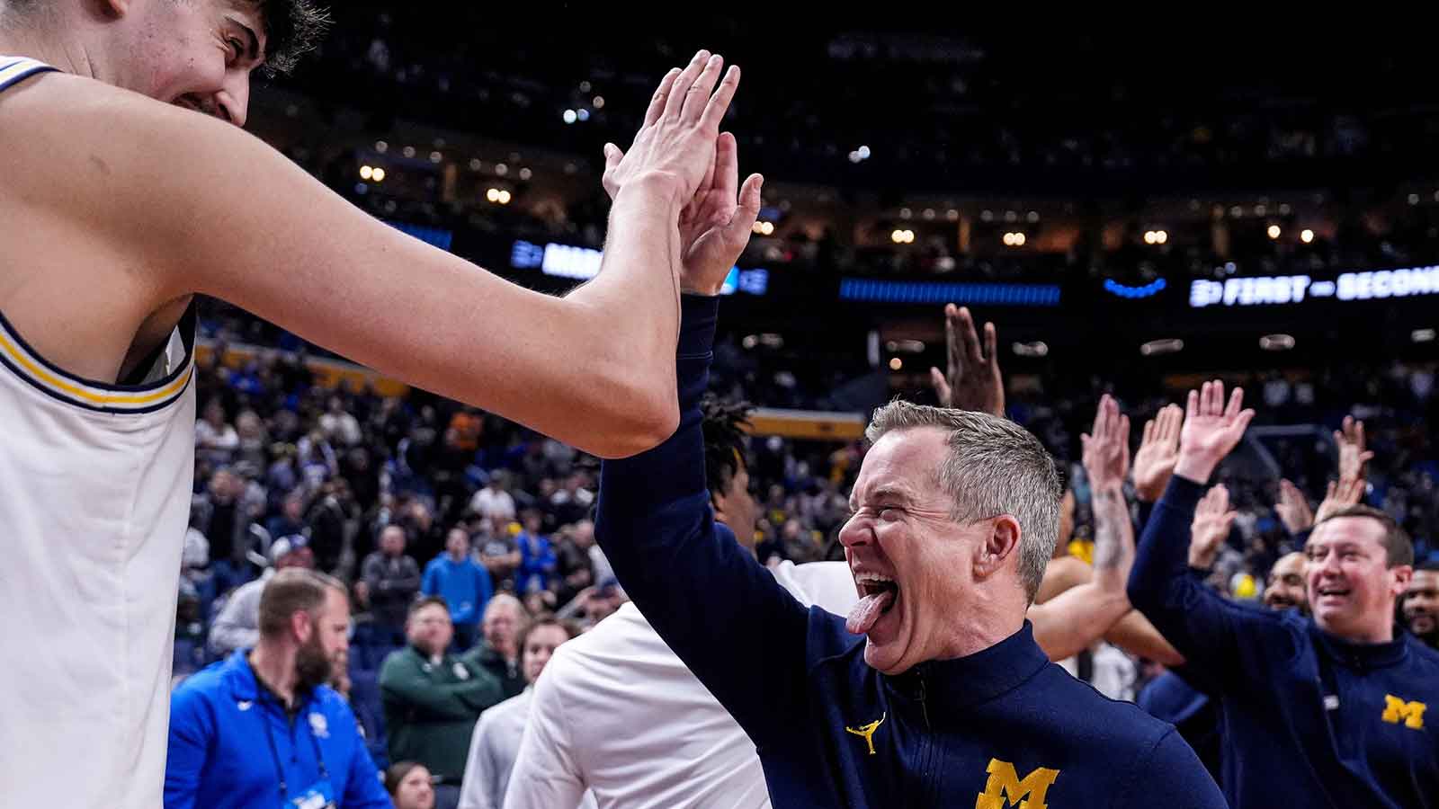 Michigan head coach Dusty May high-fives players after 95-72 win over Saint Louis at the NCAA Tournament Second Round at KeyBank Center in Buffalo on Saturday, March 21, 2026.