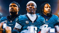 Riq Wollen (No. 7), Hollywood Brown (No. 13), and Dameon Pierce (No. 31) in Eagles uniforms in front of the Eagles stadium.