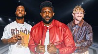 Former NFL stars Le'Veno Bell and Emmanuel Acho next to Logan Paul in a boxing ring.