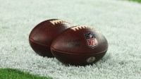 Official NFL game balls sit on the field prior to a 2024 NFC wild card game between the Philadelphia Eagles and Tampa Bay Buccaneers at Raymond James Stadium.