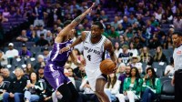San Antonio Spurs guard De'aaron Fox (4) drives to the basket against Sacramento Kings guard Nique Clifford (5) during the first quarter at Golden 1 Center