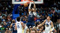 Dallas Mavericks forward Daniel Gafford (21) dunks over Golden State Warriors center Kristaps Porzingis (7) and Golden State Warriors forward Gui Santos (15) during the second half at American Airlines Center.
