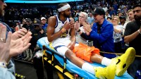Golden State Warriors guard Moses Moody (4) waves to fans while leaving the court on a stretcher during overtime against the Dallas Mavericks at American Airlines Center.