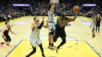 Golden State Warriors forward Draymond Green (23) shoots against San Antonio Spurs guard Dylan Harper (2) and forward Victor Wembanyama (1) in the fourth quarter at Chase Center.