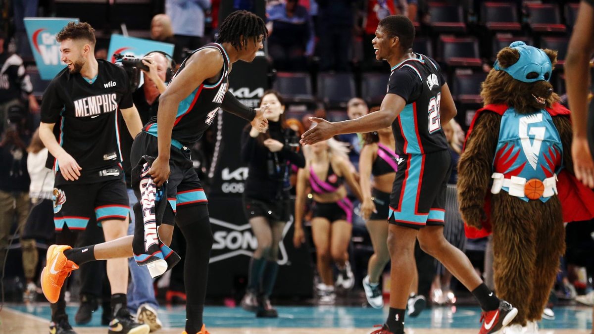 Grizzlies forward GG Jackson (45) reacts with forward Cedric Coward (23) after defeating the Denver Nuggets at FedExForum with the Celtics logo and an injury report in the background