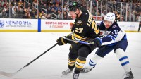 Winnipeg Jets center Morgan Barron (36) challenges Boston Bruins defenseman Hampus Lindholm (27) for the puck during the second period at TD Garden.