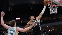Hornets guard Kon Knueppel (7) defends Bucks' Giannis Antetokounmpo