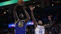 Golden State Warriors forward Draymond Green (23) goes up for a basket beside Oklahoma City Thunder guard Cason Wallace (22) during the second half at Paycom Center.