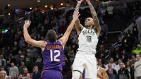 Milwaukee Bucks forward Kyle Kuzma (18) shoots over Phoenix Suns guard Collin Gillespie (12) during the first quarter at Fiserv Forum.