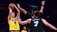 Los Angeles Lakers forward Dalton Knecht (4) shoots against San Antonio Spurs guard Dylan Harper (2) and center Luke Kornet (7) during the first half at Crypto.com Arena.