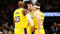 Los Angeles Lakers forward LeBron James (23) with guard Luka Doncic (77) and guard Austin Reaves (15) against the Phoenix Suns at Mortgage Matchup Center.