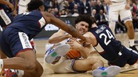 UConn Huskies guard Braylon Mullins (24) forces a jump ball with Duke Blue Devils forward Cameron Boozer (12) in the second half during an Elite Eight game of the East Regional of the men's 2026 NCAA Tournament at Capital One Arena.