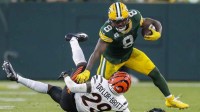 Green Bay Packers running back Josh Jacobs (8) stiff-arms Cincinnati Bengals cornerback Cam Taylor-Britt (29) during the game at Lambeau Field.