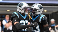Carolina Panthers linebacker Isaiah Simmons (27) reacts with cornerback Robert Rochell (33) after making a tackle in the first quarter in an NFC Wild Card Round game at Bank of America Stadium.