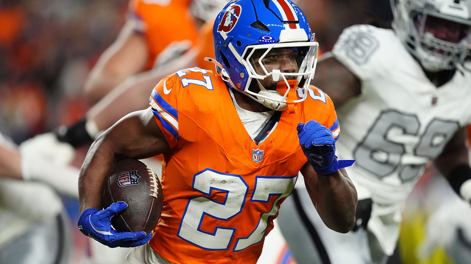 Denver Broncos running back J.K. Dobbins (27) rushes the ball against the Las Vegas Raiders during the first half at Empower Field at Mile High. 