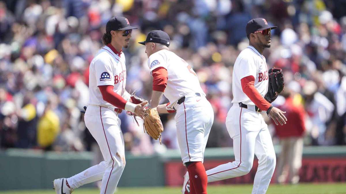 Boston Red Sox center fielder Jarren Duran (16) and Boston Red Sox third baseman Alex Bregman (2) shake hands to celebrate the victory after the ninth inning against the Chicago White Sox at Fenway Park.